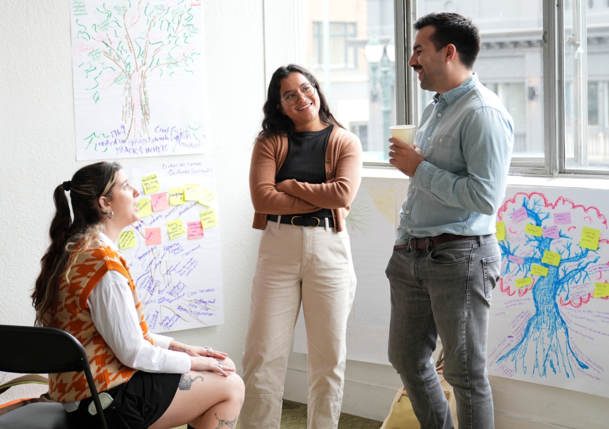 Three people connecting happily at a conference