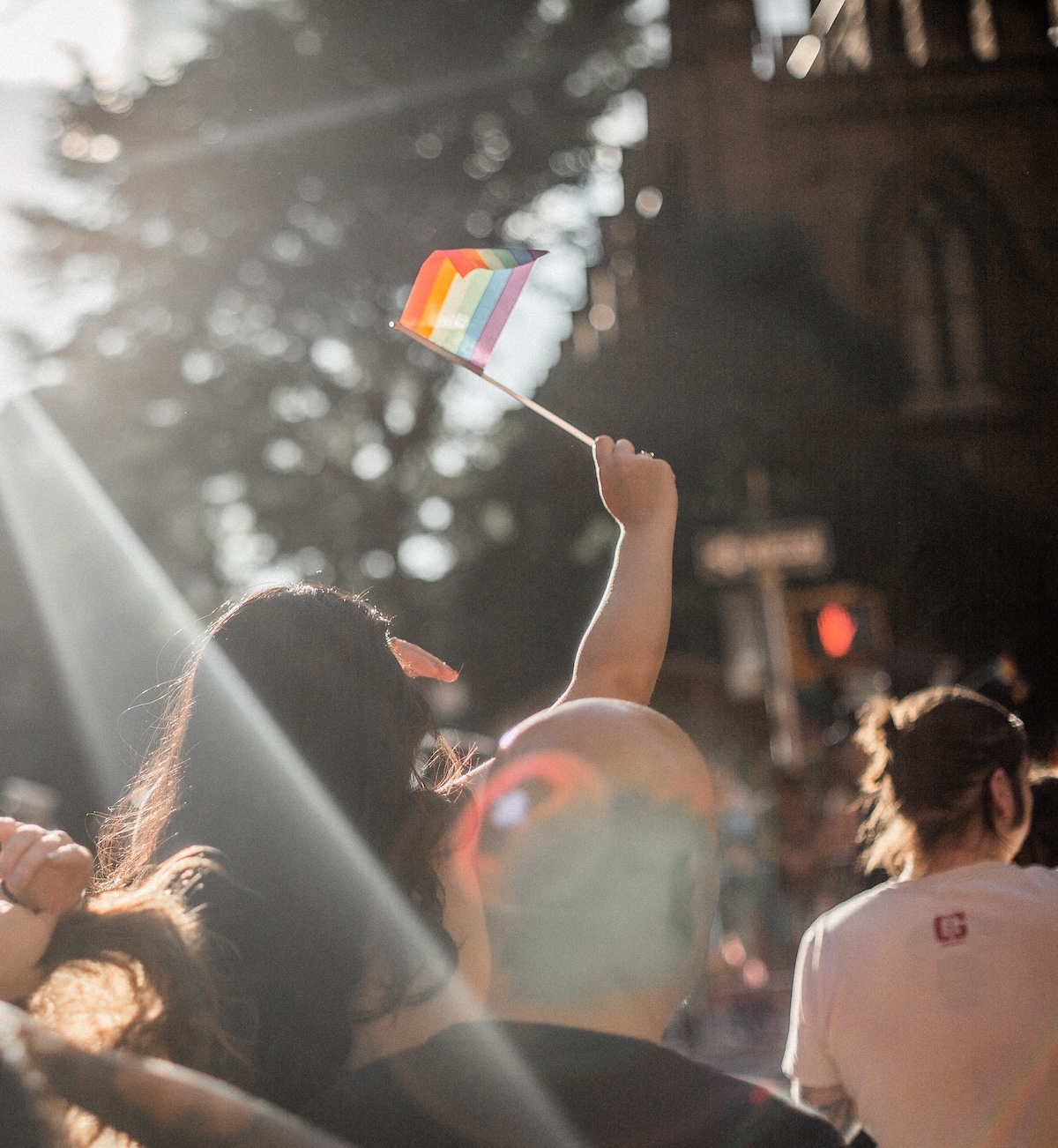 Girl at protest holding rainbow trans flag